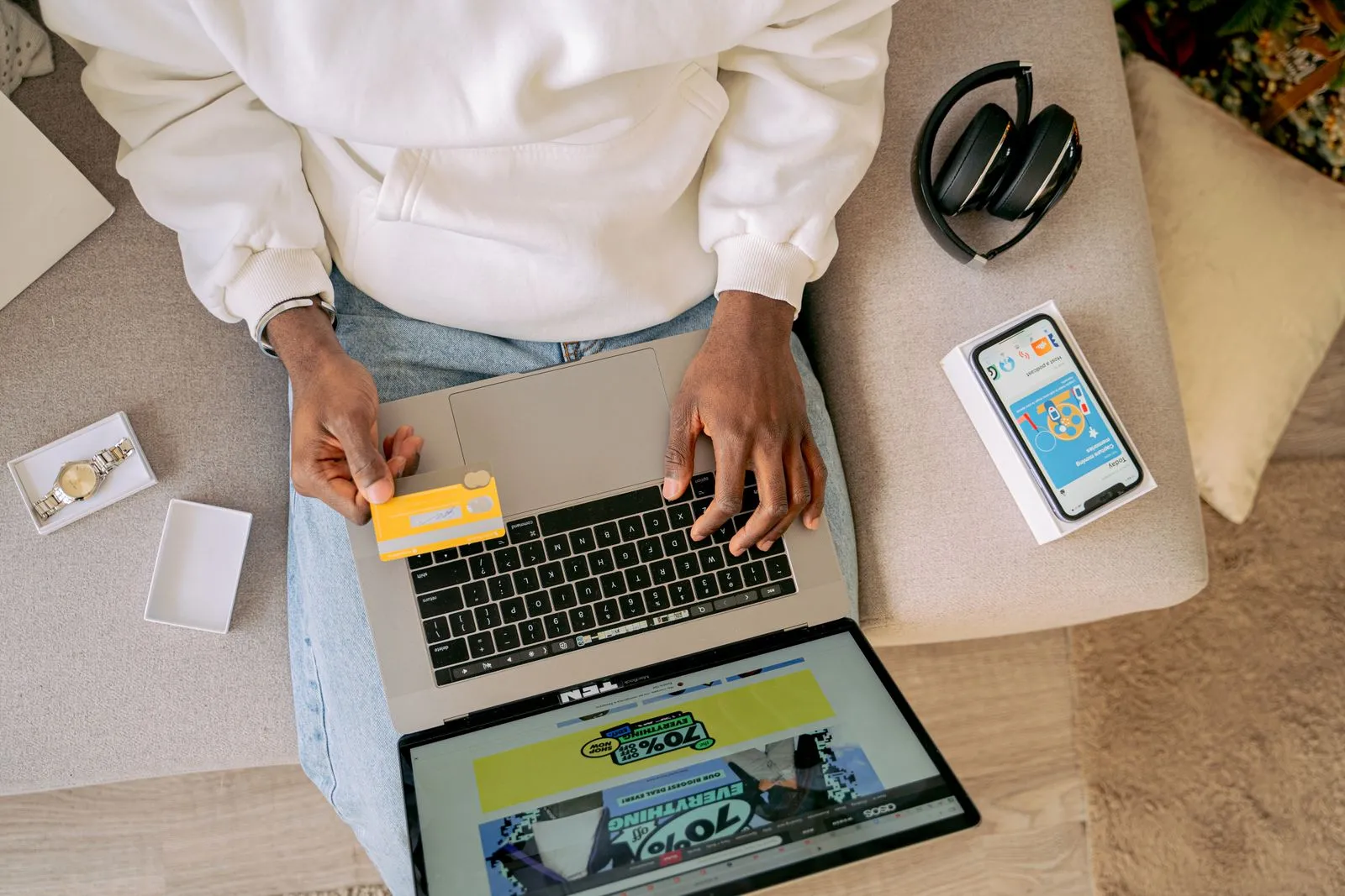 Woman sitting on a couch browsing an online store on a laptop